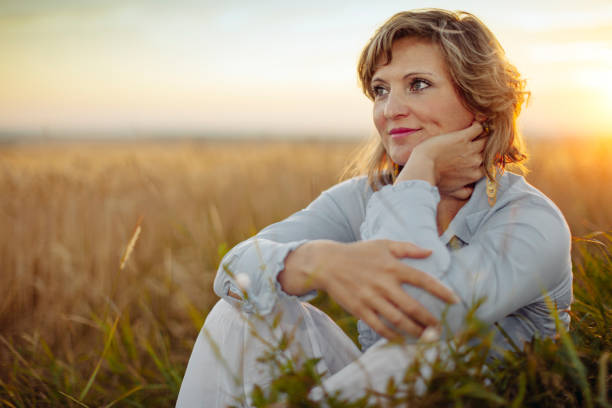 Mulher madura sorridente representando bem-estar após iniciar a terapia hormonal na menopausa