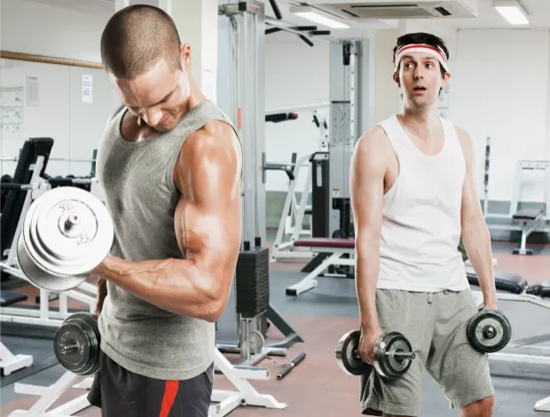 Homem sentado em academia durante pausa nos treinos, ilustrando perda de massa muscular após período sem exercício