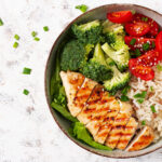 Prato com arroz branco, frango grelhado e legumes, refeição rica em proteínas para hipertrofia muscular
